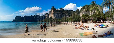 KRABI - JANUARY 20, 2015 : Tourist enjoying a beach walk and sunbathing on a sunny day JANUARY 20, 2015 at Railay Beach in Krabi, Thailand. Railay Beach is a small peninsula with white sand beaches, soaring limestone cliffs, viewpoints, caves and a lagoon
