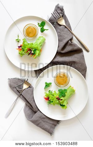 Lettuce vegetarian wraps or rolls stuffed with freshly chopped juicy vegetables and herbs served with sauce and decorated with fresh mint leaves view from above