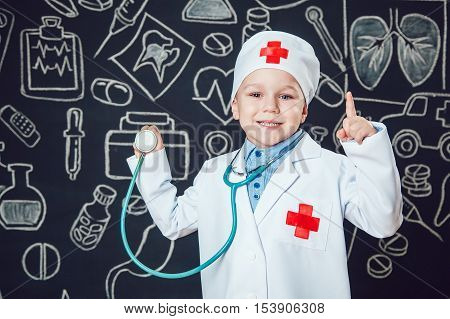 Happy boy playing a doctor holding a sthetoscope - isolated over white