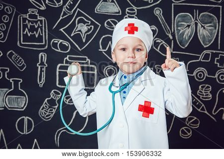 Happy boy playing a doctor holding a sthetoscope - isolated over white