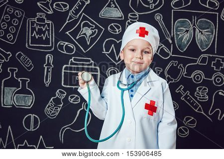 Happy boy playing a doctor holding a sthetoscope - isolated over white