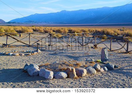 Grave surrounded by rocks and sand at a cemetery taken in the Great Basin Desert