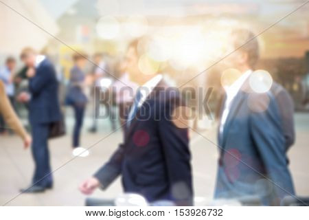 Business people walking in the City, blurred image with lights reflection. Business and modern life concept