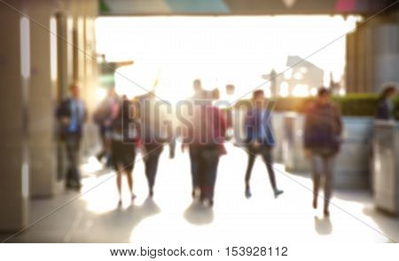 Business people walking in the City, blurred image with lights reflection. Business and modern life concept