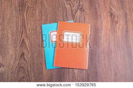 Two Colored Exercise Books On The Wooden Table