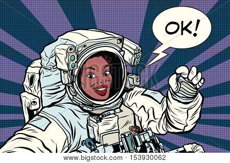 OK gesture woman astronaut in a spacesuit, pop art retro comic book vector illustration