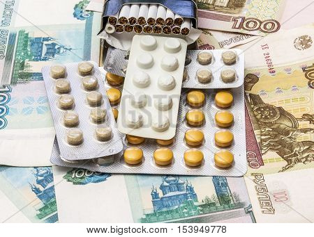 On banknotes is a pack of cigarettes and packaging of medical drugs