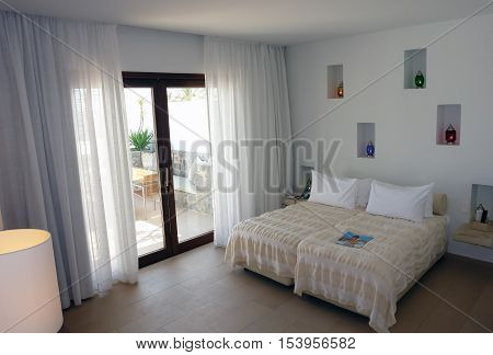 HERAKLION CRETE GREECE - MAY 13 2014: The Interior room with big bed colour lamps and terrace in modern building of luxury class hotel on the Mediterranean coast of Crete May 13 2014 Greece.