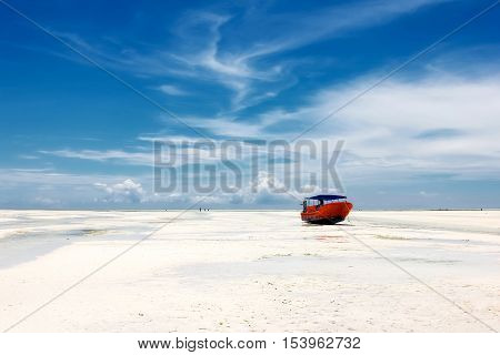 Red boat on the beach of Zanzibar on the blue sky background. Africa. Zanzibar.