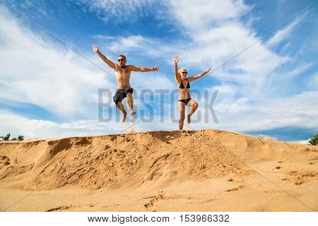 Happy couple on a beach on a background of blue sky and clouds