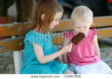 Two Little Sisters Eating Ice Cream