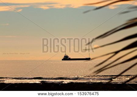 The silent ship sailing at the sunset