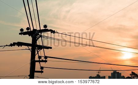Electricity power plant and city concept - Electric pole in city with evening light and space for text