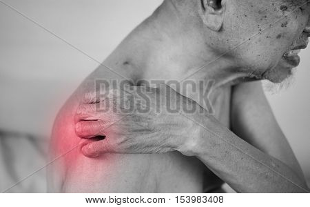 senior man holding he shoulder on pain area. red effect