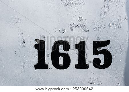 Street Numbers 1615 On White Chipped Faded Worn Paint On A Wall