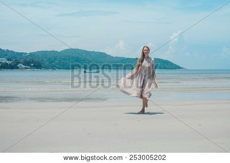 Beautiful Girl Dancing On The Beach. Portrait Of A Woman In White Clothes On The Sea. Dancer On The 