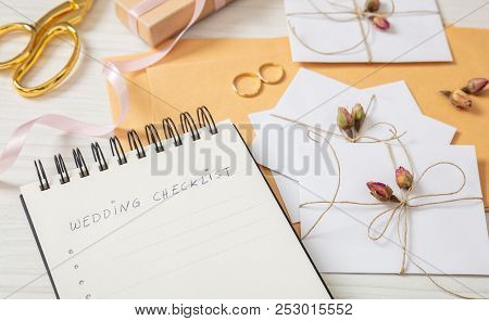 Wedding Preparation.flat Lay And Close Up View Of Checklist And Wedding Invitations On A White Woode