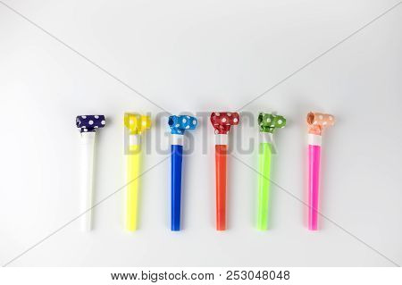 Festive Multi-colored Pipes Lying On A White Table. Minimalistic Style. Top View. Flat Lay. Place Fo