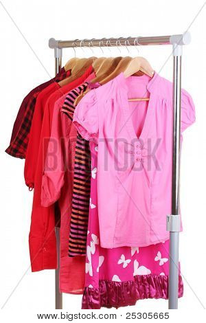 เสื้อผ้าที่แตกต่างกันบน hangers แยกต่างหากบนพื้นสีขาว