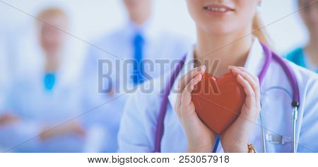 Female doctor with stethoscope holding red heart