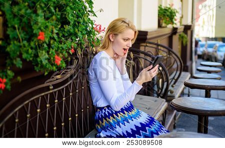 Shocking Content. Woman Surprised Face Surfing Internet Smartphone Cafe Terrace Urban Background. La