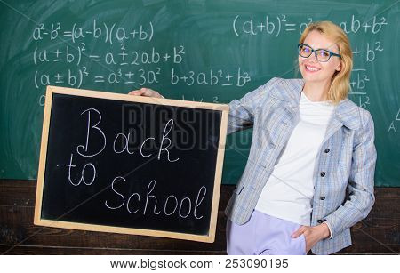 Beginning Of New School Season. Woman Teacher Formal Suit Holds Blackboard Inscription Back To Schoo