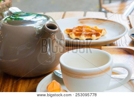Tea Pot, Mug And Belgian Waffle For Breakfast Are Set On Wooden Table For A Lovely Day