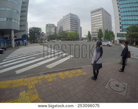 Fukuoka, Japan - April 27, 2016: Typical Japanese School Girl Is Crossing The Street