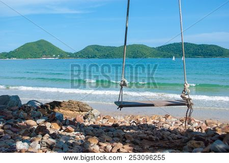 Lonely Wooden Swings In Front Of The Blue Sea