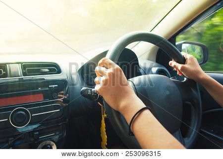 Tan-skinned Woman Hands Controling Car Steering Wheel