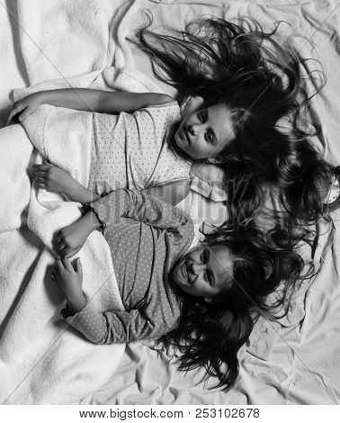 Schoolgirls In Pink Pajamas Wallow On Colorful Pillows, Top View