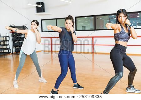 Determined Women In Sportswear Punching The Air In Gym
