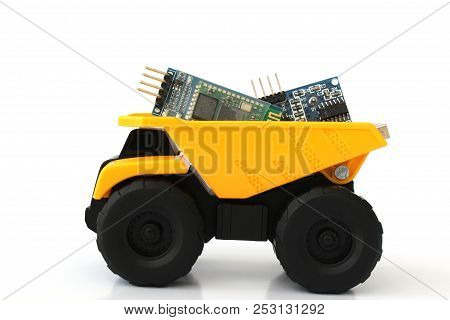 Isolated Toy Truck In Yellow And Black Colors With White Background And Electronic Parts