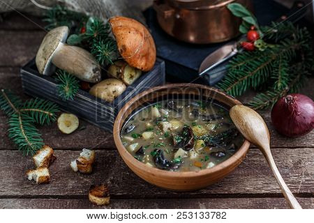 Mushroom Soup In Ceramic Bowl With A Copper Pan And Mushroom In Background, Dark Photo.