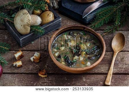 Mushroom Soup In Ceramic Bowl With A Copper Pan And Mushroom In Background, Dark Photo.