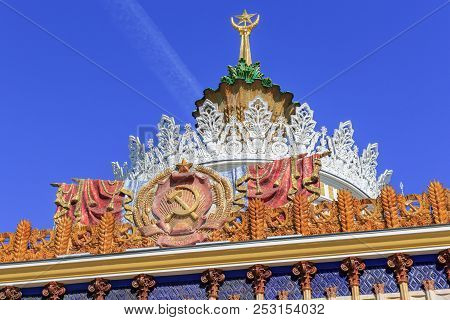 Moscow, Russia - August 01, 2018: Coat Of Arms Of Ukrainian Ssr Against Gilded Spire With Soviet Sta