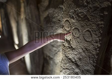 Trigueros, Spain - July 2nd, 2018: Child Pointing To Dolmen De Soto Engravings, Circles. The Biggest