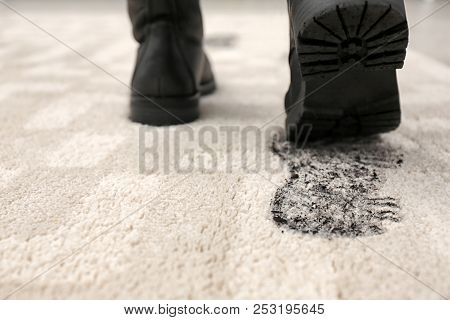 Person In Dirty Shoes Leaving Muddy Footprints On Carpet