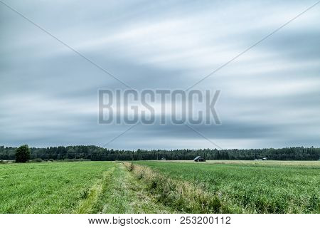 Barns In Farmfield With A Cloudy Sky.