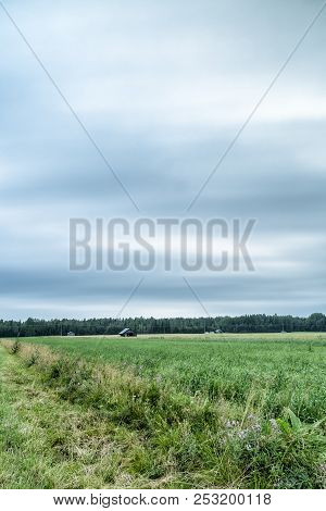 Barns In Farmfield With A Cloudy Sky.