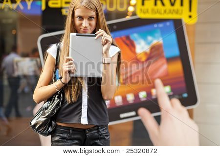 Ung kvinna med Tablet PC går på gatan