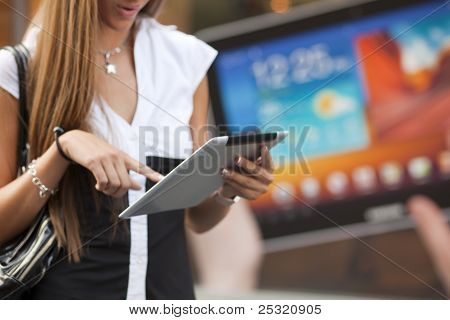 Ung kvinna med Tablet PC går på gatan