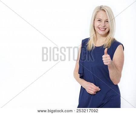 Happy Caucasian Female Wearing Dress Making Thumb Up Sign And Smiling Cheerfully, Showing Her Suppor
