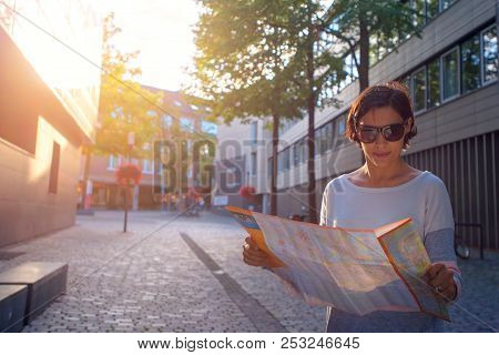 Woman With Map In The Street Searching For A New Place To Visit