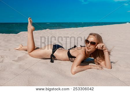 Single Happy Young Blond Woman In Swimsuit And Sunglasses At Sand Sea Beach Tanning, Toned Image