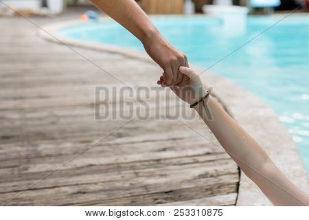 Man Hand Reach Helpnig Achild In A Local Pool On Vacation.