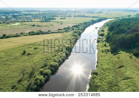 Flying Over The Village, Fields, River And Forests. Beautiful Bird's-eye View On Hanging Old Bridge 