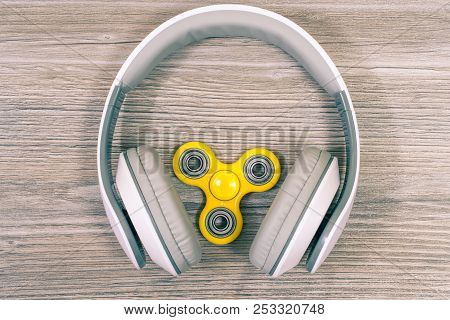 Close Up Top View Photo Of Headphones And Modern And Hot Toy Fidget Spinner