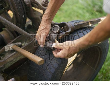 Closeup Of Mechanic Hands Repairing Tractor, Outdoor Shot