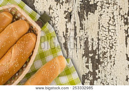 Buns In A Wicker Basket On Old Wooden Table. Top View.